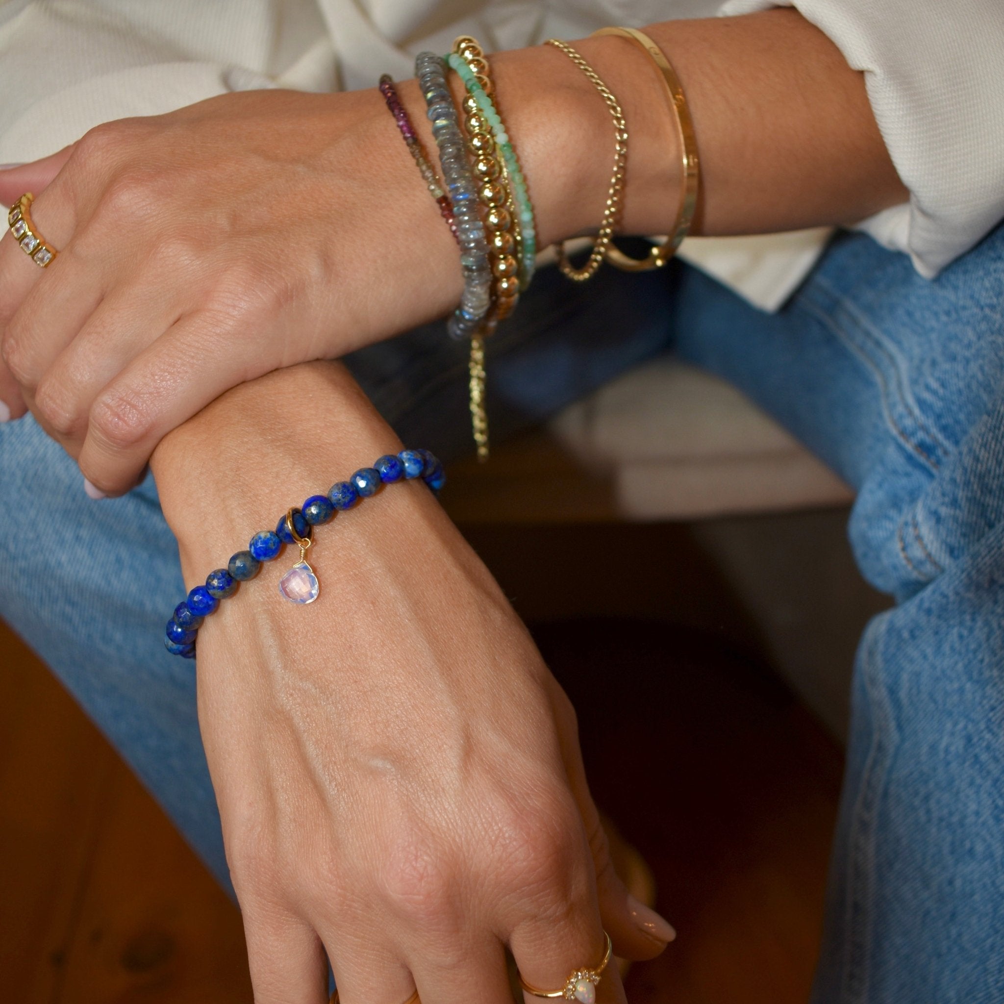natural lapis lazuli gemstone stretch beaded bracelet complimented with 14K gold plated hardware and one single opal teardrop charm. trendy jewelry made in Vermont, perfect for casual wear, date night, work, weddings, gifting, or everyday wear.