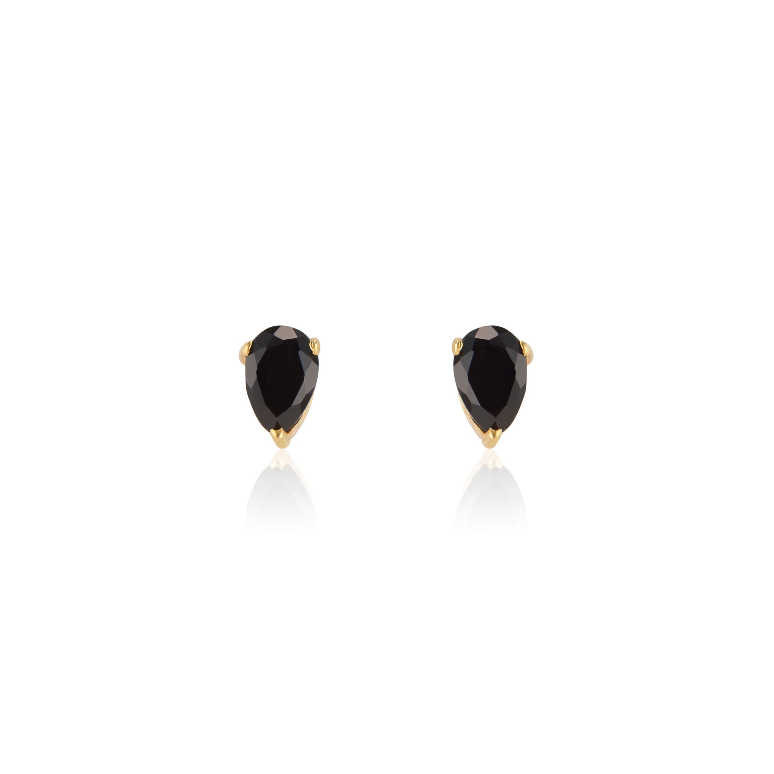 Close-up of elegant black onyx teardrop stud earrings set in 14K gold vermeil displayed on a neutral-toned fabric background. The polished onyx stones are cut in a teardrop faceted shape, reflecting light for a subtle shine—handcrafted minimalist jewelry made in Vermont from Elli Parr.
